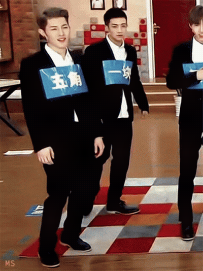 Man In Suit With Blue Sign Saying 五角 GIF