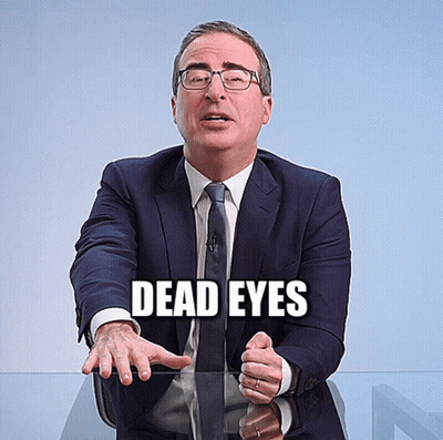 Man In Suit With Dead Eyes Written On Face GIF