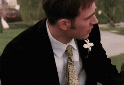 Man In Suit With Flower Lapel Looking Down GIF
