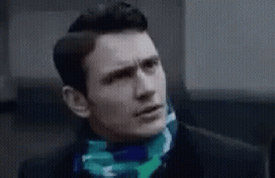 Man In Suit With Scarf Looking At Camera GIF
