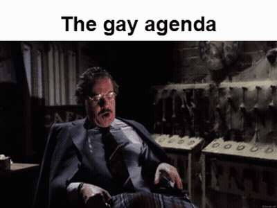 Man In Suit With The Gay Agenda Above Him GIF