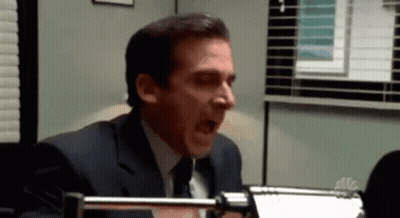 Man In Suit Yawning In Front Of NBC Sign GIF