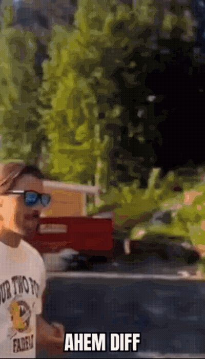 Man in Sunglasses and Ahem Diff T-Shirt in Front of Red Truck