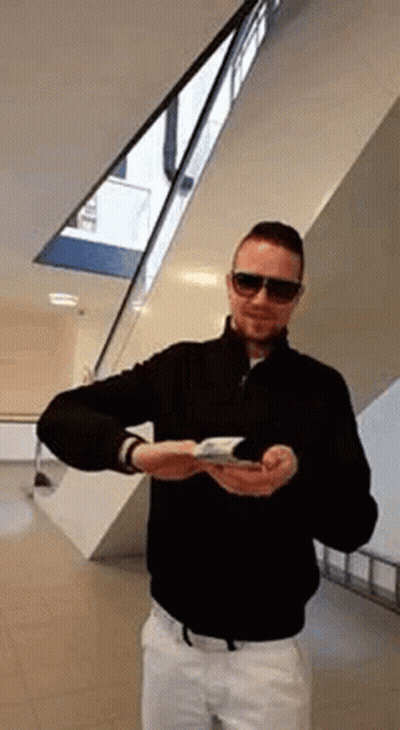 Man In Sunglasses And Black Jacket Holding Book GIF