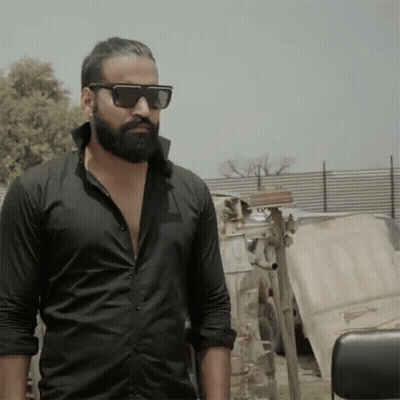Man In Sunglasses And Black Shirt In Front Of Fence GIF
