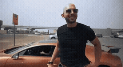 Man In Sunglasses And Black Shirt Next To Orange Car GIF