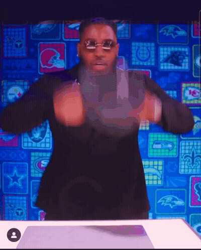 Man In Sunglasses And Black Suit In Front Of NFL Logos GIF