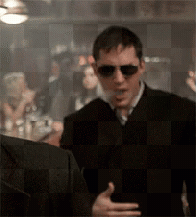 Man in Sunglasses and Black Suit Talking in Bar