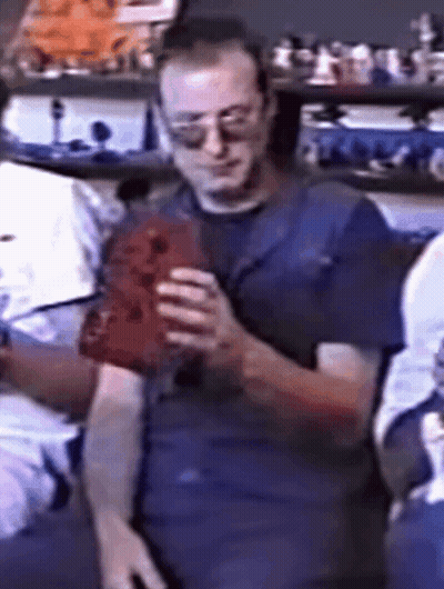 Man In Sunglasses And Blue Shirt Holding Red Object GIF