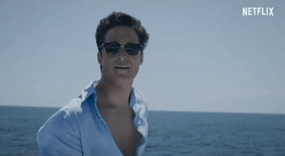Man In Sunglasses And Blue Shirt In Front Of Netflix Banner GIF