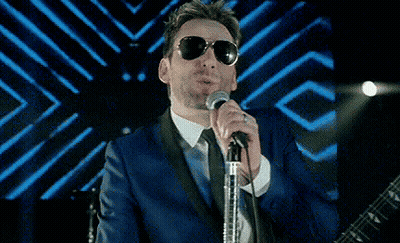 Man In Sunglasses And Blue Suit Singing GIF