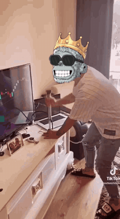 Man in Sunglasses and Crown Standing in Front of Laptop and TV