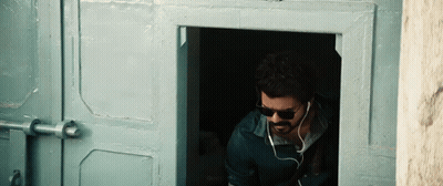 Man In Sunglasses And Earbuds At Doorway GIF