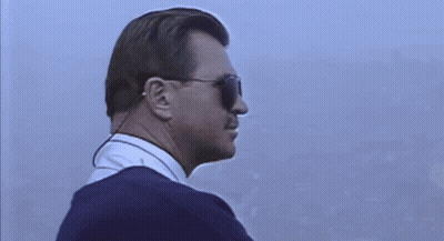 Man In Sunglasses And Earpiece Looking To Side GIF