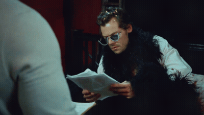 Man In Sunglasses And Fur Coat Looking At Paper GIF