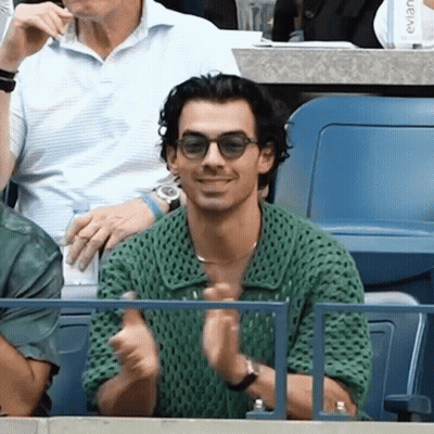 Man In Sunglasses And Green Shirt At Stadium GIF