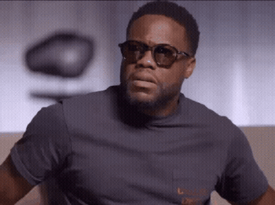 Man In Sunglasses And Grey T-Shirt Looking At Camera GIF