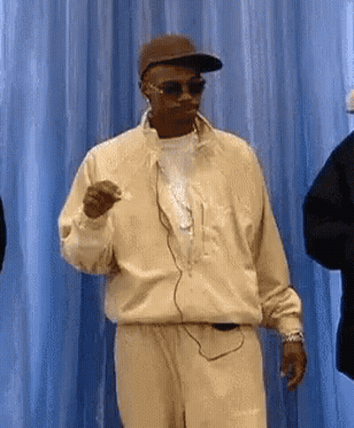 Man In Sunglasses And Hat Dancing In Front Of Blue Curtain GIF
