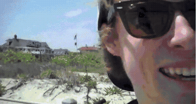 Man In Sunglasses And Hat Smiling Near House GIF