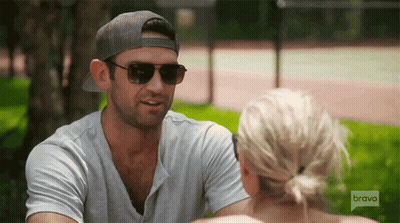 Man In Sunglasses And Hat Talking To Woman On Bravo GIF