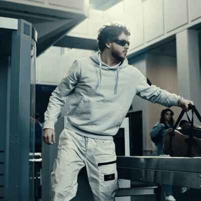 Man In Sunglasses And Hoodie Carrying Suitcase GIF