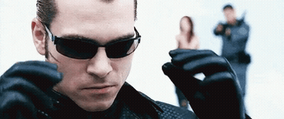 Man In Sunglasses And Leather Gloves Standing In Front Of Woman GIF