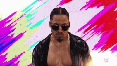 Man In Sunglasses And Necklace Before Wrestling Logo GIF