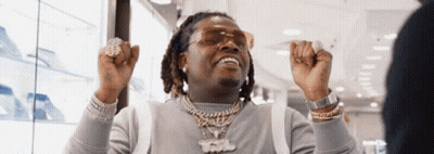Man In Sunglasses And Necklace Raising Hands In Store GIF