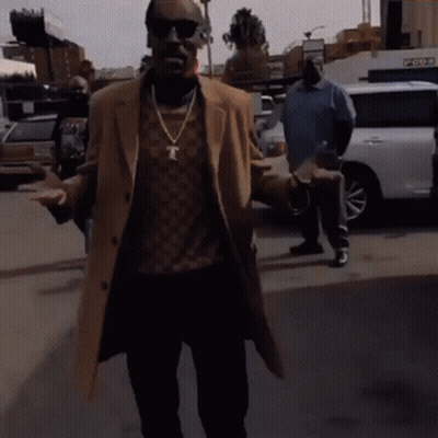 Man In Sunglasses And Necklace With Letter T Walking Down Street GIF