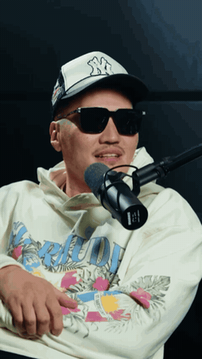 Man In Sunglasses And NY Hat Talking Into Microphone GIF