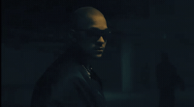 Man In Sunglasses And Pearl Necklace In Dark Room GIF