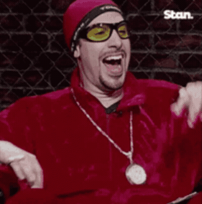 Man In Sunglasses And Red Jacket Laughing With Der War Böse Sign GIF