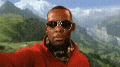 Man In Sunglasses And Red Jacket Taking Selfie With Mountain GIF