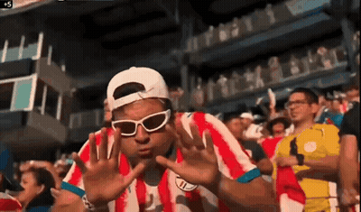Man In Sunglasses And Red Striped Shirt In Crowd GIF