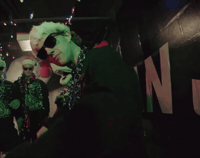 Man In Sunglasses And Santa Hat Dancing In Dark Room GIF
