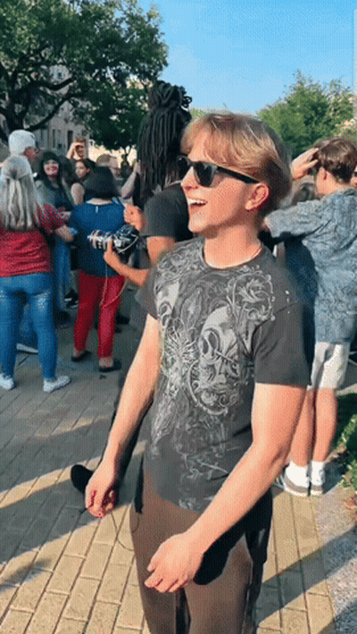 Man In Sunglasses And Skull Shirt In Front Of Crowd GIF