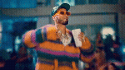 Man In Sunglasses And Striped Jacket Holding Coffee On Stage GIF