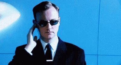 Man in Sunglasses and Suit Talking on Phone