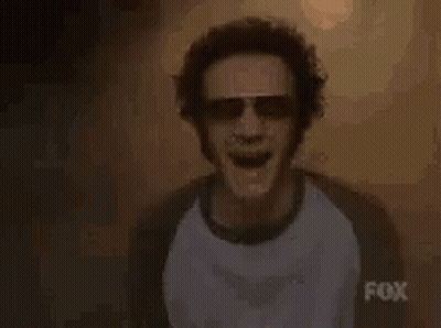 Man In Sunglasses And T-Shirt In Front Of High Sign GIF