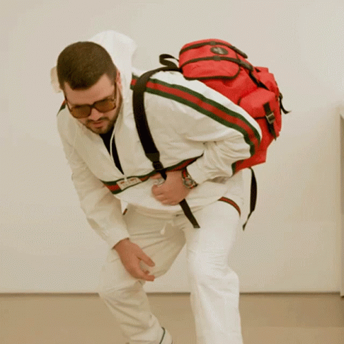 Man In Sunglasses And White Jacket With Red Backpack GIF