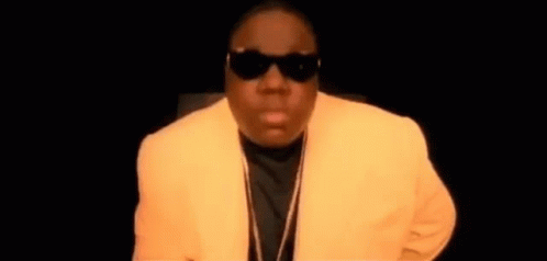 Man In Sunglasses And Yellow Jacket In Dark Room GIF