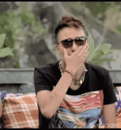 Man In Sunglasses Covering Mouth On Couch GIF