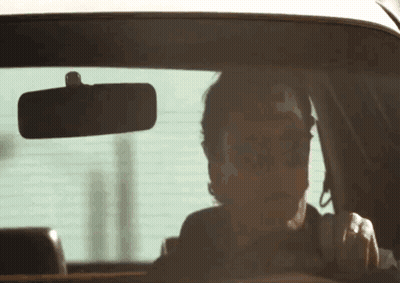 Man In Sunglasses Driving And Looking At Rear View Mirror GIF