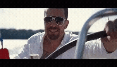 Man In Sunglasses Driving Boat Holding Wine GIF