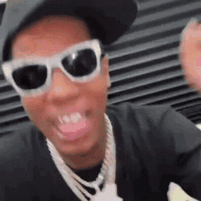Man In Sunglasses Hat And Necklace Smiling GIF