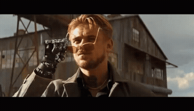 Man In Sunglasses Holding Camera In Front Of Building GIF