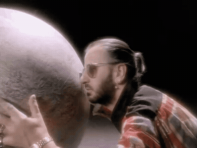 Man In Sunglasses Holding Globe In Dark Room GIF