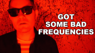Man In Sunglasses In Front Of Red Wall Saying Got Some Bad Frequencies GIF