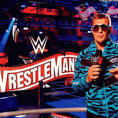 Man In Sunglasses In Front Of Wrestlemania Sign GIF