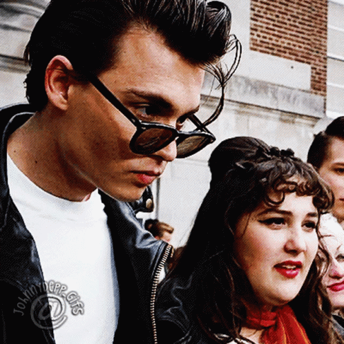Man In Sunglasses Next To Woman In Tommy Hilfiger Shirt GIF